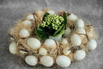 Decorative nest with white eggs and flower arrangement.
