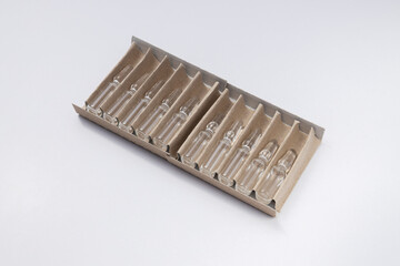 Ampoules in the cardboard blister on white background