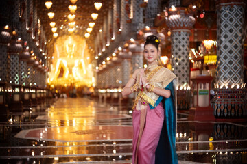 Beautiful young Asian woman in traditional Myanmar dress in an old temple in Chiang Mai, Thailand. 