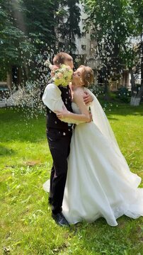 A beautiful wedding video. The happy newlyweds take photos in a park with soap bubbles.