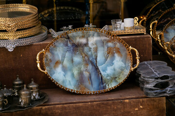 Decorative serving tray with a blue agate surface and golden handles displayed in a vintage...