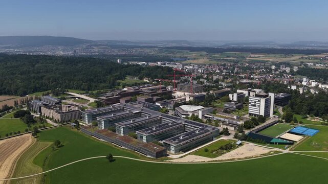 Aerial view of HCP ETH Honggerberg campus surrounded by green fields and a forest