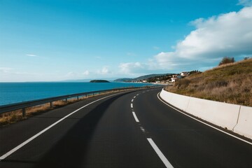 Fototapeta premium A scenic road by the sea under a clear blue sky