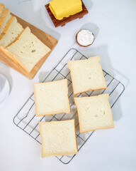 Slices of fresh white bread on cooling rack with butter and flour