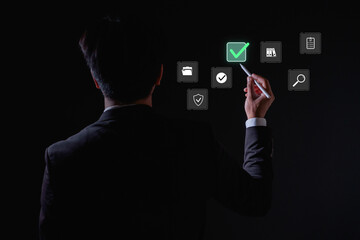 Businessman using digital pen to select virtual checklist icons on futuristic screen, concept for project management, business planning, task completion data organization.