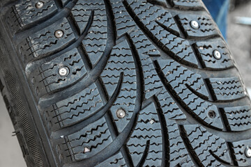 Checking winter tire with holes where spikes fell out
