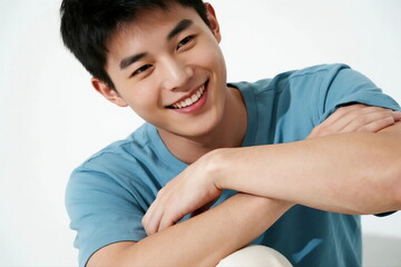 A young man with a cheerful expression wearing a light blue T-shirt