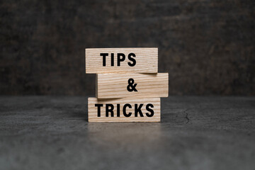 tips and tricks words on wooden blocks isolated on dark background