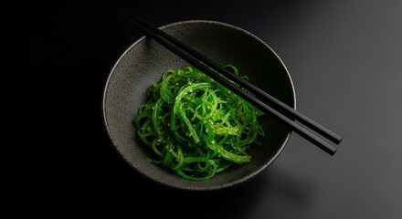 Green Seaweed Salad in Bowl with Chopsticks.
