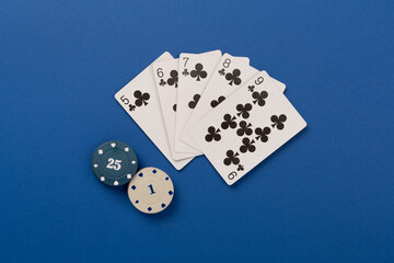 Poker chips and playing cards on color background, top view. Casino card game