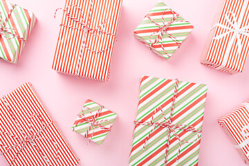 Obraz premium Many striped Christmas gift boxes on color background, top view