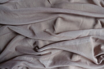 Folded dull dusky pink unprinted polyester mesh fabric
