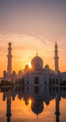 Naklejka premium A magnificent white mosque with domes and minarets reflected in still water during a beautiful golden sunrise.