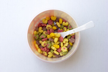 A bowl of colorful cereals isolated on white background.