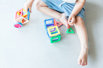 Toddler playing with magnetic building tiles