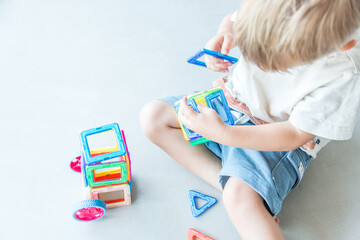Toddler playing with magnetic building tiles