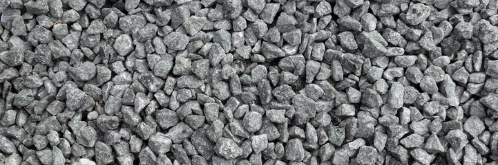 Light gray granite gravel road background. Closeup. Wide banner. Top down view.