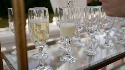 Waiter pouring champagne into glasses on a table for a celebration