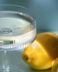 Drink in a glass, blue background, lemons, deep shadows