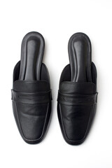 Classic black leather slide loafers on white background, a close up photo of luxurious black leather women's mules.