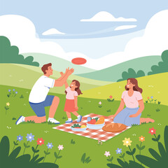 Family having a picnic and playing frisbee in a grassy park with rolling hills father