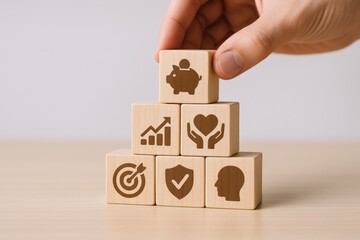 Building Blocks of Financial Security: Hand Stacking Wooden Cubes with Investment, Growth, and Protection Icons