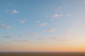 Serene Sunset Sky with Soft Clouds: Panoramic Aerial View of Pastel Colors and Horizon