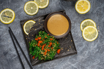 Chukka salad with pepper, caviar and sauce on a gray background