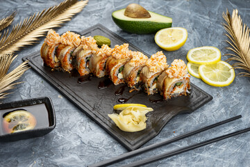 Philadelphia sushi roll in sesame on the table with soy sauce