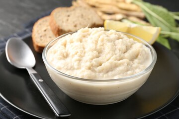Tasty horseradish sauce served on black table, closeup