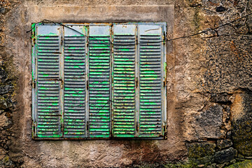 Window in a stone wall. Rural architecture in Spain abandoned and semi-demolished due to migration to cities.