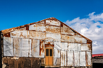 Rural architecture in Spain, abandoned and semi-ruined due to migration to cities, with blue skies.