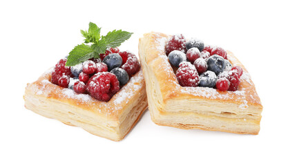 Tasty puff pastries with berries, powdered sugar and mint isolated on white