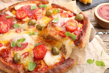 Taking piece of delicious pizza with cheese, tomatoes and olives at table, closeup