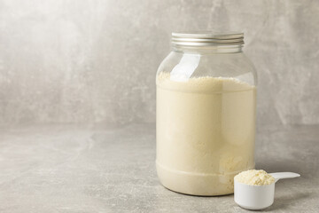 Protein shake with protein powder on a colored background. The powder is mixed with water or milk. A dietary supplement for a balanced diet. Whey protein. Fitness and gym diet nutrition.