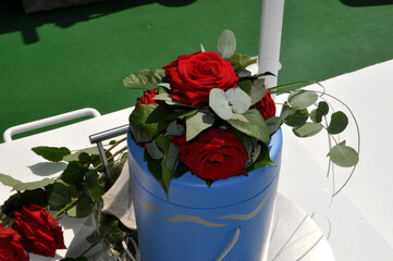 Seebestattung: eine blaue Urne mit Rosen wird auf das offene Meer gefahren.