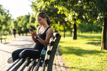 Woman, smile and phone on run, nature and digital by message, notification. Happy person, trail and exercise for fitness, sportswear and sweat in outdoors, workout and health by cardio, break and fit.