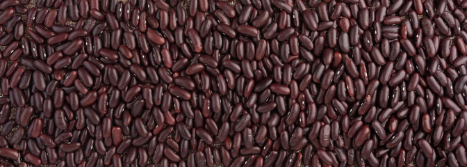 Obraz premium Red raw kidney beans textured background. Dry legume grains pattern, protein seeds wallpaper