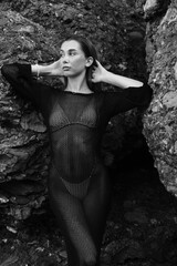 Black and white portrait ypung woman at  summer sea shore against rock mountain