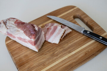 Ukrainian traditional cuisine. Very tasty pieces of salo. Raw ukrainian bacon or salo on wooden board. Sliced salted pork lard (salo). Food concept.