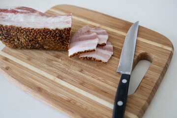 Ukrainian traditional cuisine. Very tasty pieces of salo. Raw ukrainian bacon or salo on wooden board. Sliced salted pork lard (salo). Food concept.