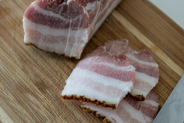 Ukrainian traditional cuisine. Very tasty pieces of salo. Raw ukrainian bacon or salo on wooden board. Sliced salted pork lard (salo). Food concept.
