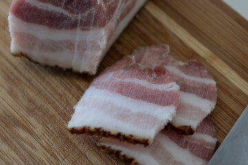 Ukrainian traditional cuisine. Very tasty pieces of salo. Raw ukrainian bacon or salo on wooden board. Sliced salted pork lard (salo). Food concept.