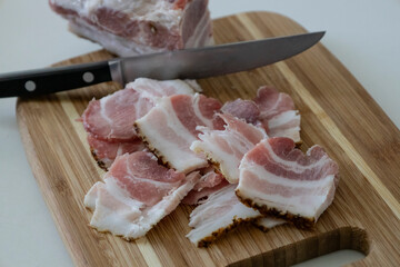 Ukrainian traditional cuisine. Very tasty pieces of salo. Raw ukrainian bacon or salo on wooden board. Sliced salted pork lard (salo). Food concept.