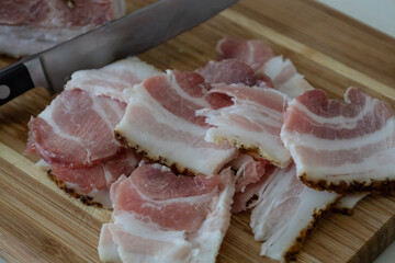 Ukrainian traditional cuisine. Very tasty pieces of salo. Raw ukrainian bacon or salo on wooden board. Sliced salted pork lard (salo). Food concept.