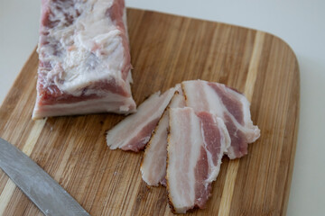 Ukrainian traditional cuisine. Very tasty pieces of salo. Raw ukrainian bacon or salo on wooden board. Sliced salted pork lard (salo). Food concept.