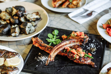 Delicious grilled lamb chops served with various side dishes on a table.