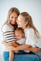 mother with children and daughters, maternal love and care, mother and child hug and kiss on a white isolated background, a family with two children