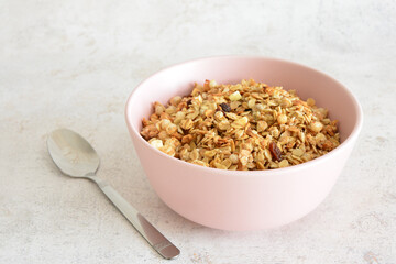 Granola in a Pink Bowl with a Silver Spoon close up