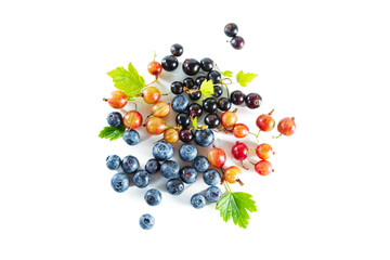 Ripe fresh blueberries, blackcurrants and gooseberries with leaves on a white background.